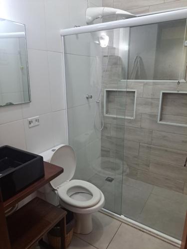 a bathroom with a toilet and a glass shower at Casa do Mar & Ane Ilhabela in Ilhabela
