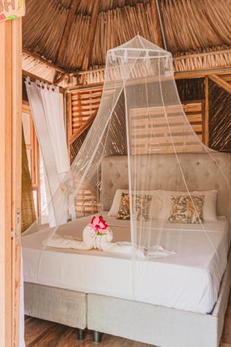 a bedroom with a bed with mosquito net at Magic Green Dentro del Parque Tayrona in El Zaino