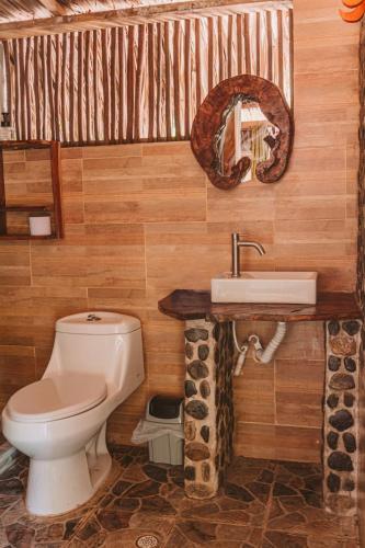 a bathroom with a toilet and a sink at Magic Green Dentro del Parque Tayrona in El Zaino