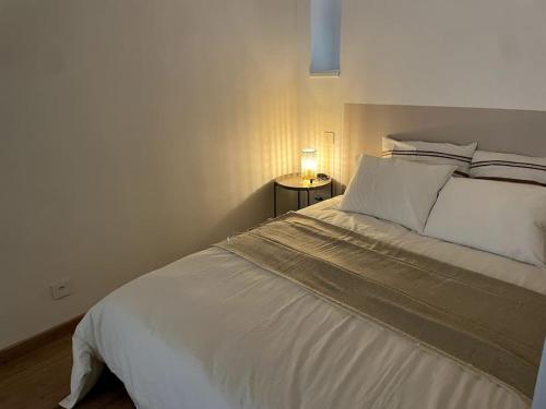 une chambre avec un lit blanc et une table de chevet dans l'établissement Studio Obernai Centre, à Obernai