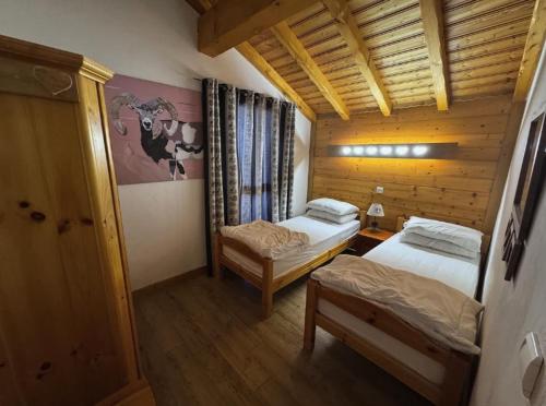 - une chambre avec 2 lits dans une pièce en bois dans l'établissement Apartment Ciel Étoilé, à Les Coches