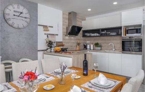a kitchen and dining room with a table and a clock at Villa Manali in Jadranovo