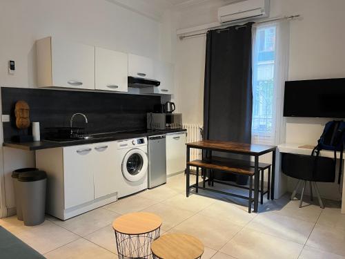 une cuisine avec une machine à laver et une table dans l'établissement Appartment 2 pieces hyper centre ville, à Nice