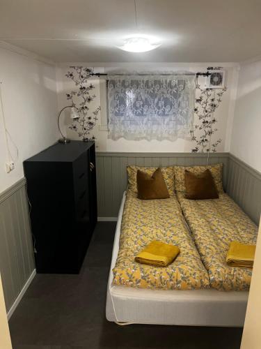 a bedroom with a bed with two yellow towels on it at Hoda Apartment - Cozy central apartment with free parking in Leknes