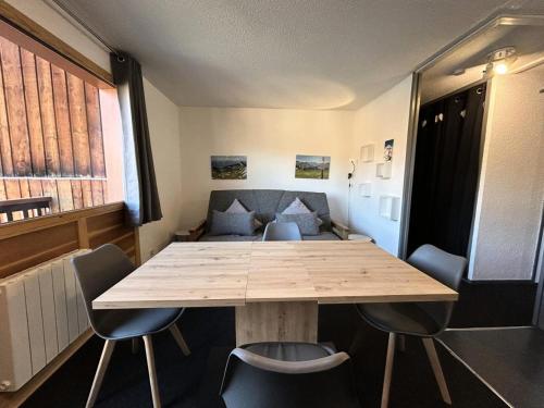 - une table dans une pièce avec des chaises et un canapé dans l'établissement Résidence Perce Neige - Résidence PERCE NEIGE N°31 MAE-4971, à La Plagne Tarentaise
