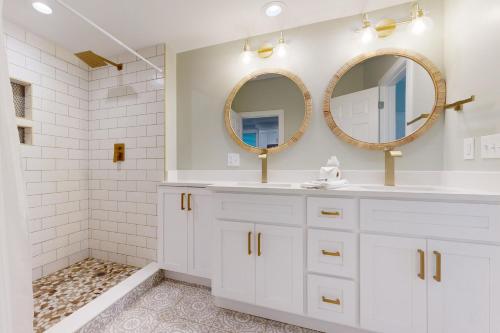 a white bathroom with two mirrors and a sink at 126 Grand Pavilion in Isle of Palms