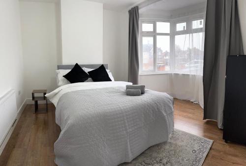 a white bedroom with a bed and a window at stadium home in London