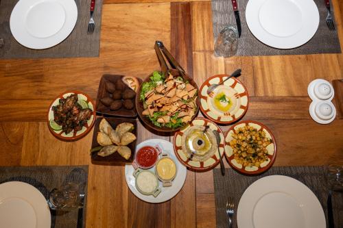 a wooden table with plates of food on it at Lodge du Ranch de Bandia in Sindia