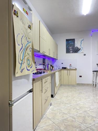 a kitchen with wooden cabinets and a white refrigerator at Maison D'artiste Boutique Hostel in Tirana