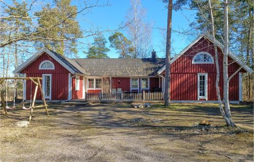 a red house with a playground in front of it at Amazing Home In Köpingsvik With Sauna in Köpingsvik