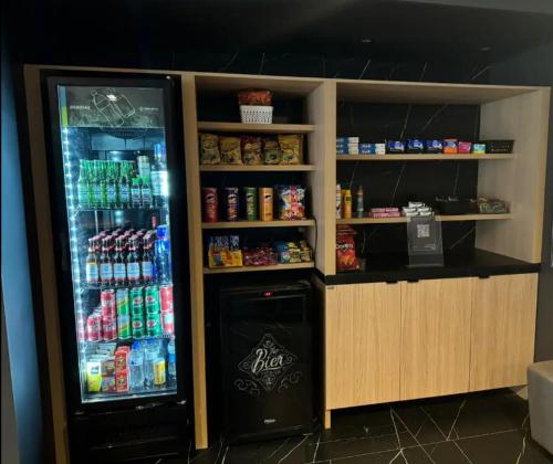 a drink counter with a refrigerator with drinks at Melhores Flats - Espaçoso, pertinho do mar in João Pessoa