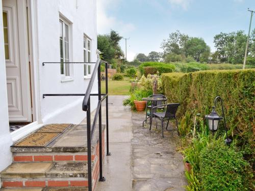 a patio with a table and chairs on a house at The Willows in Chardstock