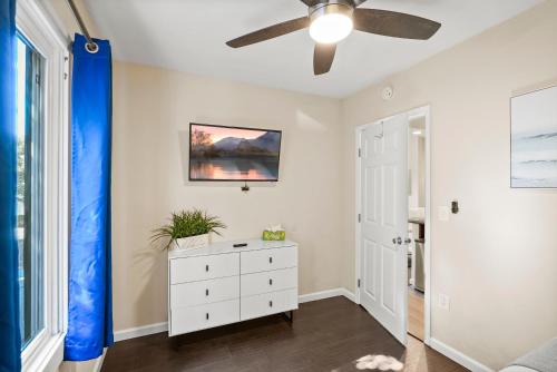 a bedroom with a ceiling fan and a dresser at Riviera Bay View Dream - Private patio with bay view and parking in San Diego