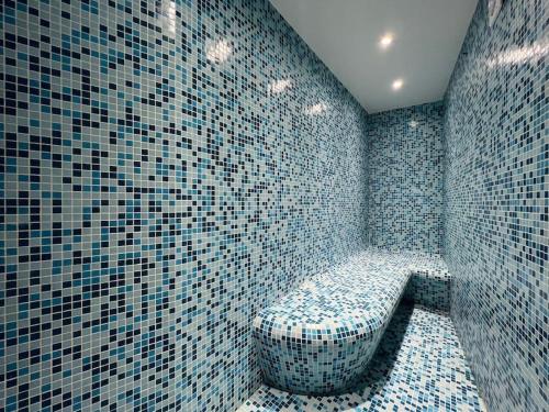 La salle de bains est pourvue de carrelage bleu et de toilettes. dans l'établissement Villa campagne - Hammam & Piscine à 1h30 de Paris, à Chantecoq