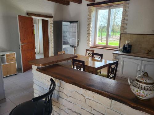 une cuisine et une salle à manger avec une table et des chaises dans l'établissement Le domaine de la remangerie, à Nogent-sur-Loir