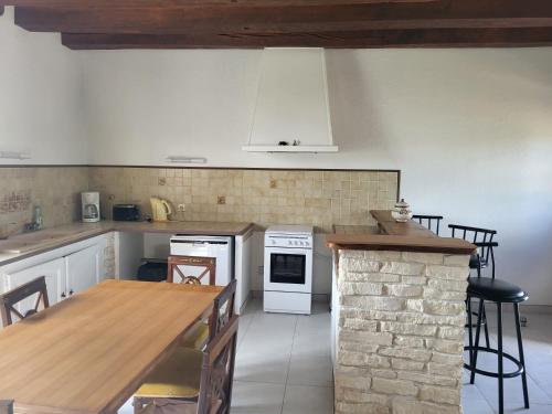 une cuisine avec une table et une cuisinière four supérieur dans l'établissement Le domaine de la remangerie, à Nogent-sur-Loir