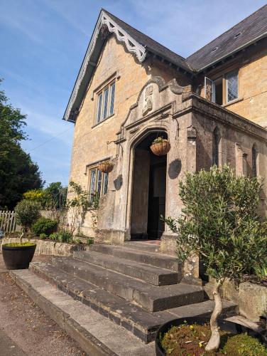 an old stone building with stairs leading to a doorway at The Duke Hotel in Hilmarton