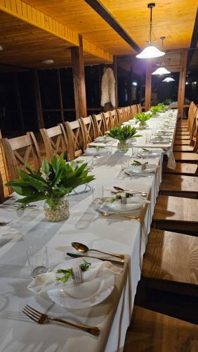 a long row of tables with white table cloths at Leśna Osada Szegdy in Szegdy
