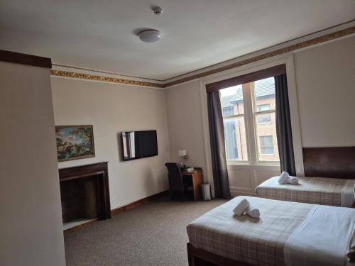 Ένα ή περισσότερα κρεβάτια σε δωμάτιο στο Douglas Hotel