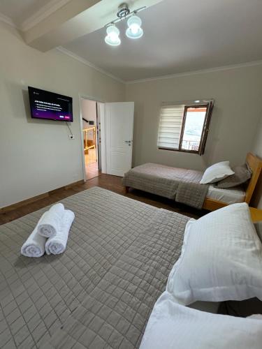 a bedroom with two beds and a flat screen tv at Villa Sana Rooms in Përmet