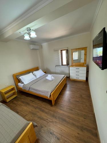 a bedroom with a bed and a flat screen tv at Villa Sana Rooms in Përmet
