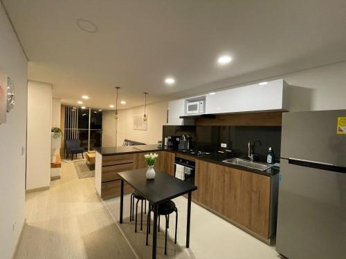 a kitchen with a table and a small kitchen with a sink at Náutica Lake Paipa - Penthouse in Paipa