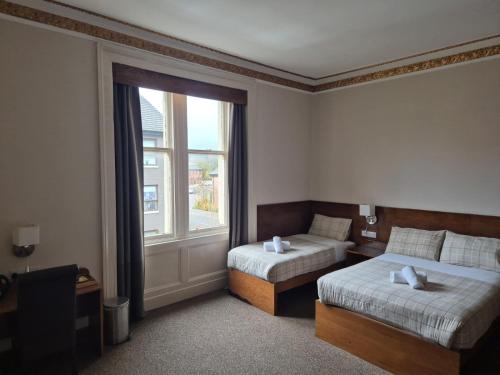 Ένα ή περισσότερα κρεβάτια σε δωμάτιο στο Douglas Hotel