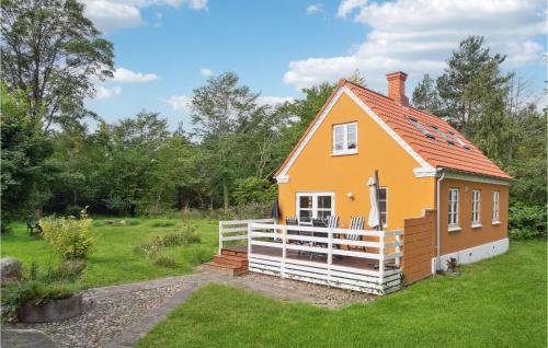 a small yellow house with a deck in a yard at Nice Home In Knebel With Kitchen in Knebel