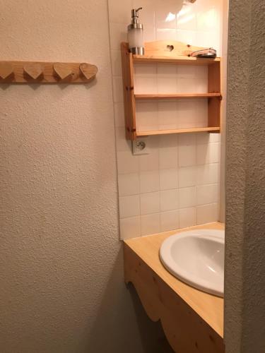 La salle de bains est pourvue d'un lavabo et d'un comptoir avec un miroir. dans l'établissement Les balcons de Sirius Risoul1850, à Risoul