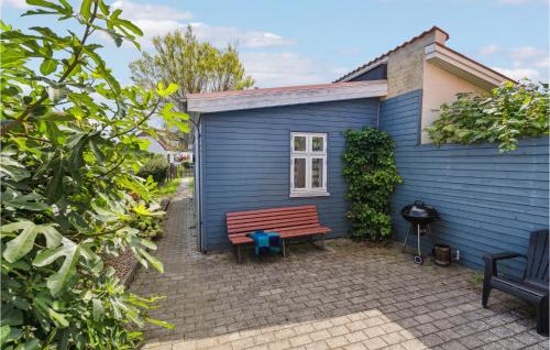 a blue house with a bench in front of it at Cozy Home In Assens With Wifi in Assens
