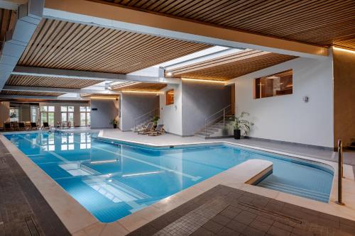 a swimming pool with blue water in a building at Radisson Blu Hotel & Spa, Daugava Riga in Rīga