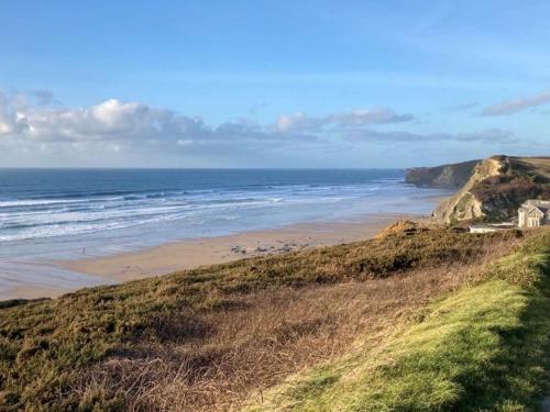 a view of a beach with a house and the ocean at 11 Meadow View in Newquay