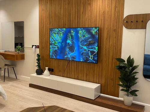 a living room with a tv on a wall at إستديو هادئ حي حطين قريب من البوليفارد in Riyadh
