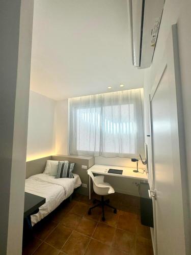 a small bedroom with a bed and a desk at Guest House Espinardo Murcia Casa Universitaria in Murcia