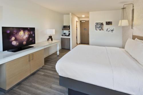 a hotel room with a large bed and a flat screen tv at Hilton Garden Inn Montgomery - EastChase in Montgomery