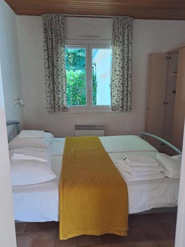 deux lits jumeaux dans une chambre avec fenêtre dans l'établissement Notre Refuge, à Écuras