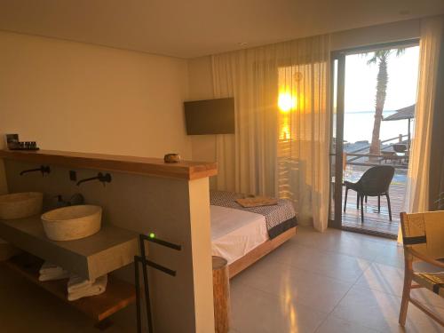 a bedroom with a bed and a bathroom with a balcony at NISSEA Boutique Hotel in Kardamaina