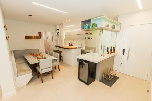 a kitchen with a table and a dining room at Conforto à beira-mar in Florianópolis