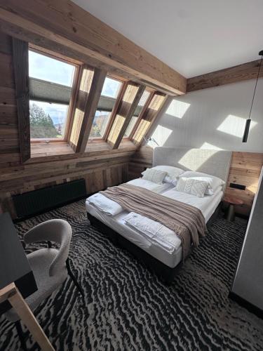 a bedroom with a large bed in a room with windows at Kama Lama in Zakopane
