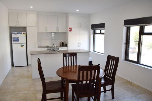 a kitchen with a table and chairs and a refrigerator at Waterford Apartment 5 in South West Rocks