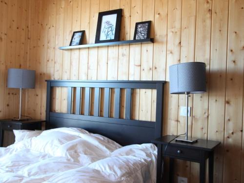 a bedroom with a bed with two lamps and two pictures at Chalet mitoyen 8 pers. 4 ch. avec terrasse à Chamrousse, animaux admis - FR-1-549-141 in Chamrousse