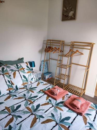 une chambre avec un lit avec une couette fleurie dans l'établissement Logement proche Caen et plages, à Colombelles