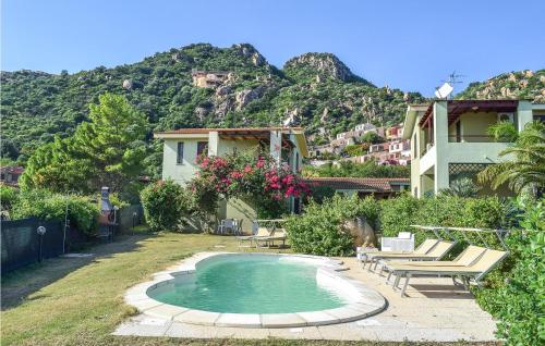 a house with a swimming pool in front of a mountain at Vespucci in Costa Rei