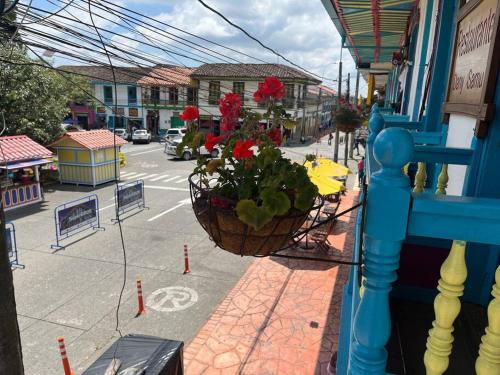 a balcony with a basket of flowers on a street at Horizonte Azul Filandia in Filandia