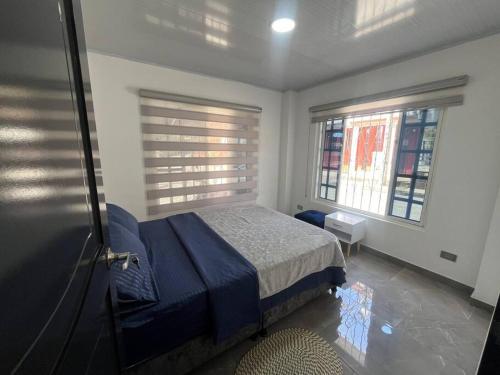 a bedroom with a blue bed and two windows at Horizonte Azul Filandia in Filandia