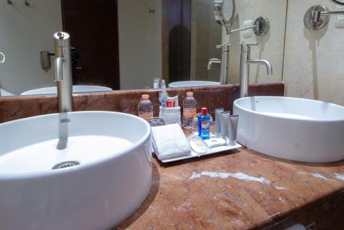 a bathroom with a sink and two mirrors at Real Inn Guadalajara Expo in Guadalajara