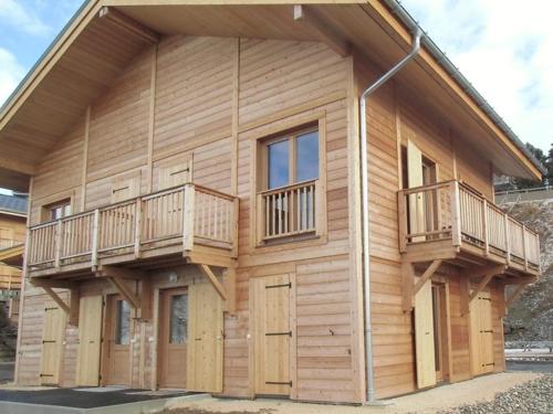 a log cabin with two decks on it at Chalet mitoyen 8 pers. 4 ch. avec terrasse à Chamrousse, animaux admis - FR-1-549-141 in Chamrousse