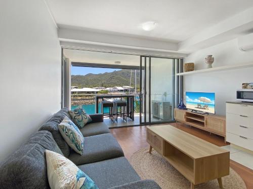 a living room with a couch and a tv at Blue on Blue Superior Studio Room 1221 in Nelly Bay