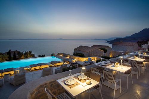 a restaurant with a pool with tables and chairs at BASSA MAINA Villas & Suites in Areopolis