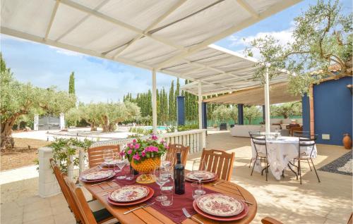 a wooden table with plates and flowers on a patio at Beautiful Home In Menfi in Menfi